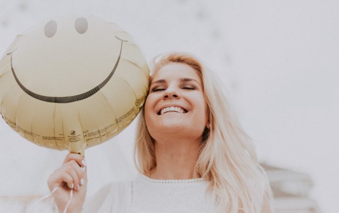 smiling woman with a smiley face balloon